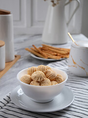 Sago Cookies are neatly presented in a white bowl with an attractive arrangement. They are isolated against a white background in a dining table setting.