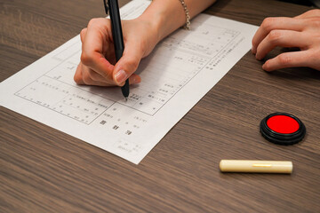 転籍届を記入する女性の手元