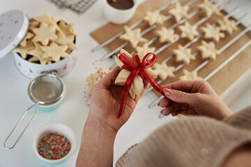 Unrecognizable woman preparing little gifts made of gingerbread cookies