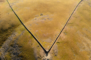 Aerial top-down at Slieve Donard's summit with mountaineers on the hilltop