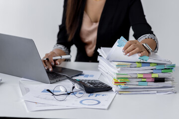 Businesswoman hands working in Stacks of paper files for searching and checking unfinished document...