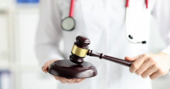 Doctor knocks on judge wooden gavel. Criminal liability of medical workers
