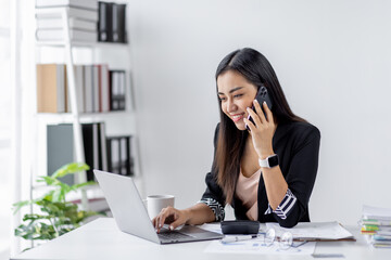 Cheerful business Asian woman office making telephone call share good news about project working in office workplace, business finance documents concept.	