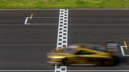 Race car blurred motion crossing the finish line on international circuit speed track, Motion blur...