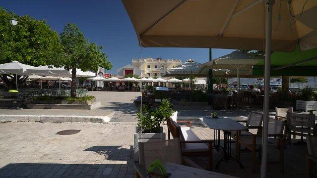 View of cafes and restaurants in Plateia Central Square through trees, Lixouri, Kefalonia (Cephalonia), Ionian Islands, Greek Islands