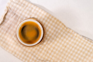 Piccolo coffee photographed from above with a checkered cloth base.