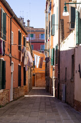 Fototapeta na wymiar Venitian architecture, no one, no people, buildings, daylight. Residential area. Venice, Italy. Old town, facade. Residential neighborhood. Romantic street, clear sky. Drying cloth.