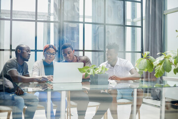 ehind the glass view of executives discussing project in modern office