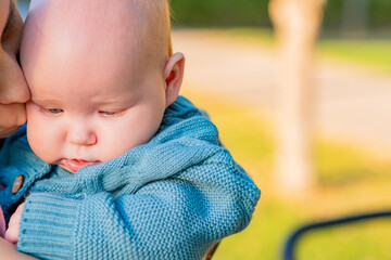 Close-up portrait of a newborn baby in the arms of his mother