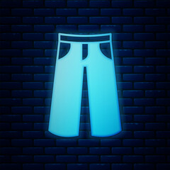 Glowing neon Pants icon isolated on brick wall background. Trousers sign. Vector
