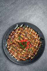 Okonomiyaki traditional japanese savoury pancake dish in restaurant on grey background - 659905953