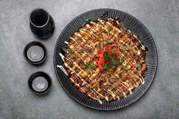 Okonomiyaki traditional japanese savoury pancake dish in restaurant on grey background - 659906149