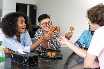 Group of young friends eating fast food at home. Multiethnic group of people having lunch together. Communication concept - 659917115