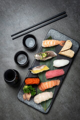 omakase mixed sushi set with sake on grey background - 659921529
