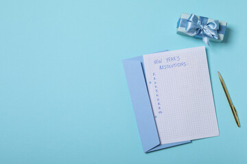 Gift box, envelope and paper with list on blue background, space for text