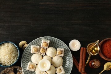 Sweets, spices, rice and candles on dark wooden background, space for text