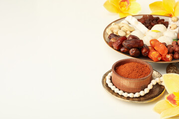 Plate with sweets, flowers and spices on white background, space for text