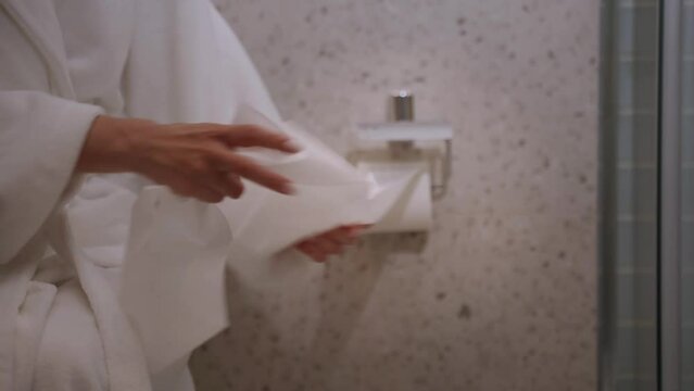 Unwinding a large amount of toilet paper in a roll in the toilet. Bowel problems, diarrhea