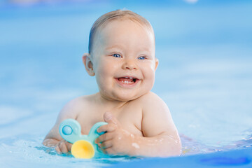 Teaching dive underwater happy baby girl in swimming pool, lesson for small swimmer