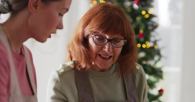 Portrait of a Young Woman Preparing Gingerbreads for Christmas While Her Senior Mother is Helping. Old Woman and Her Daughter Making Pastries for Family and Friends. Handheld Footage