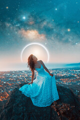 portrait beauty fantasy woman with white dress on a rock and stars and milky way over the city in...