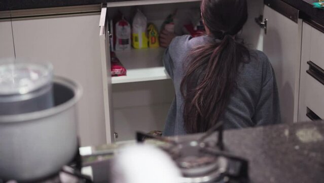 Woman putting food in pantry. Storing and organizing food in the pantry with blur

