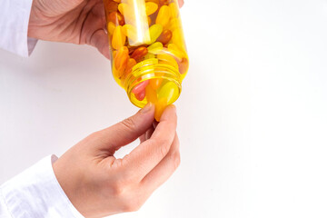 Gummy Vitamins and supplement for adults. Woman eats sweet jelly multivitamin candy microelements from transparent pills bottle, modern medicines and supplements background 