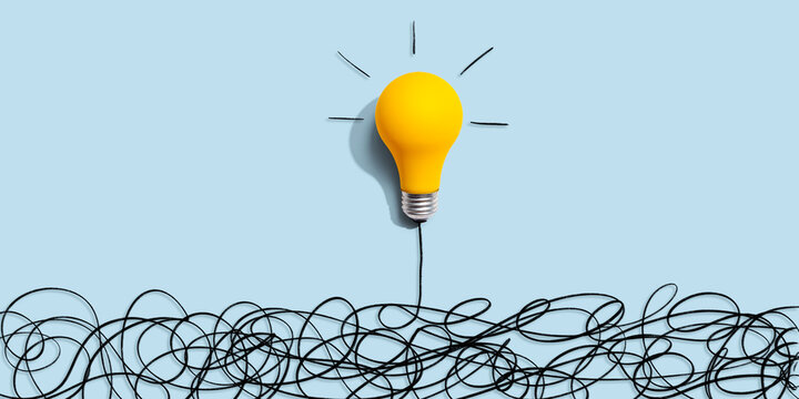 Clarifying complex ideas theme with light bulb - Flat lay