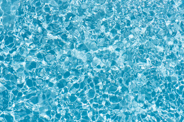 Bluewater waves on the surface ripples blurred. Defocus blurred transparent blue colored clear calm water surface texture with splash and bubbles. Water waves with shining pattern texture background.