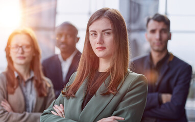 Portrait of a young serious business woman with colleagues