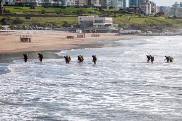Fourteen tactical divers, frogmen, enter the sea from the beach