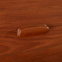 Vintage teak wood dresser. Mid-century modern gentleman's chest of drawers. Close-up detail fo the...