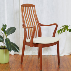Mid-century modern wooden dining room chair. Interior photograph with houseplants. 