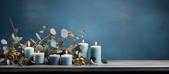 Burning light blue candles with eucalyptus on a table