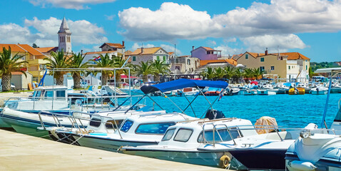 Beautiful mediterranean yacht harbor with old medieval village background against blue summer sky - Pakostane, Croatia