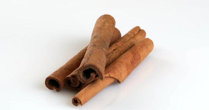 Close-up footage of a cinnamon sticks on the rotating table on the white background.