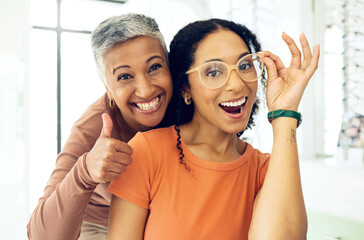 Optometry, thumbs up or happy woman with glasses for vision in a retail optical or eyewear shop. Women, smile or biracial customer with new spectacles with a mature optometrist at optics clinic store - Powered by Adobe