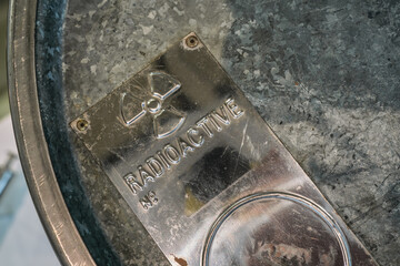 Radioactive material caution label on lead barrel top, closeup detail