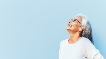 PortBeautiful elderly senior woman with grey hair wearing in glasses and sportswear smiling. Mature old lady close up portrait. Concept of health, menopause and self care. Copy space