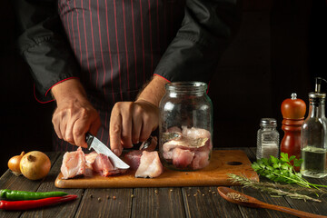 Chef cuts raw fish on a kitchen cutting board. Delicious lunch of salted carp fish for a restaurant or hotel