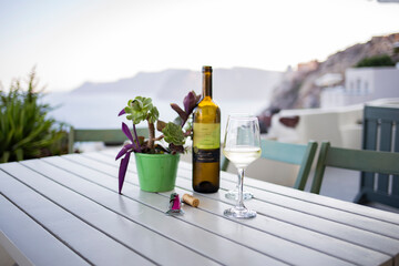 White wine served on a cold wineglass on a wooden table in Santorini, Greece