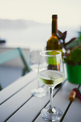 White wine served on a cold wineglass on a wooden table in Santorini, Greece