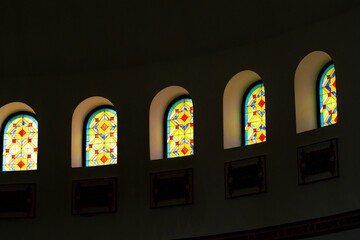 Large stained glass window with frescoes and Arabic hieroglyph in the hall inside the mosque