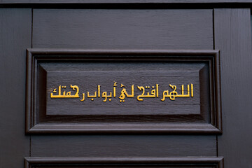 An inscription in Arabic hieroglyphs on the door at the entrance to the mosque with an appeal to Allah to be merciful to person who prays