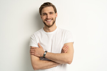 Charming, male model with bristle, wear white t-shirt, smiling amused, look entertained, happy expression, standing enthusiastic on white - obrazy, fototapety, plakaty
