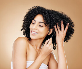Afro, hair and comb of woman in studio with healthy coil texture, natural growth or cosmetics on brown background. Happy model, curly haircare tools or brush for salon aesthetic, care or clean beauty