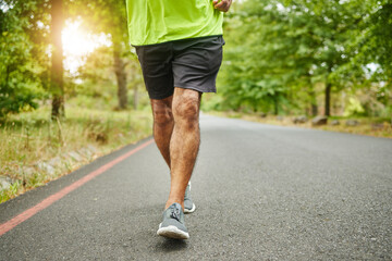 Running, workout or legs of man on road, nature or forest for trekking journey or adventure for freedom. Shoes closeup, footwear or runner on street in park or woods for exercise, fitness or wellness