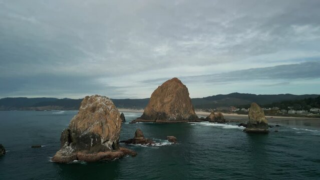 Aerial shot of Haystack Rock beach in coastal town Cannon Beach, Oregon. Wide shot footage