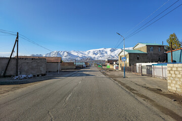 Fototapeta na wymiar Northern Mongolia. The morning City is Ulgiy. The houses of the street stretch into the distance, to the snow-capped mountains.