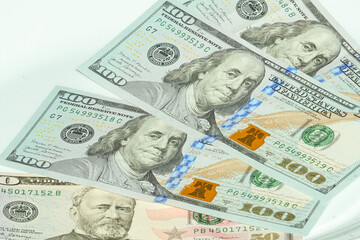 50 and 100 dollar bills of US in a white background